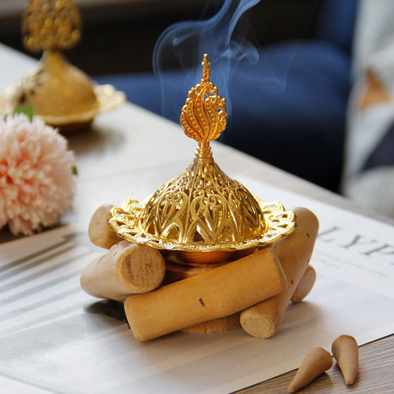 Gold Alloy Mini Incense Burner – filigree dome on stacked wood logs with incense cones and rising smoke, decorative burner