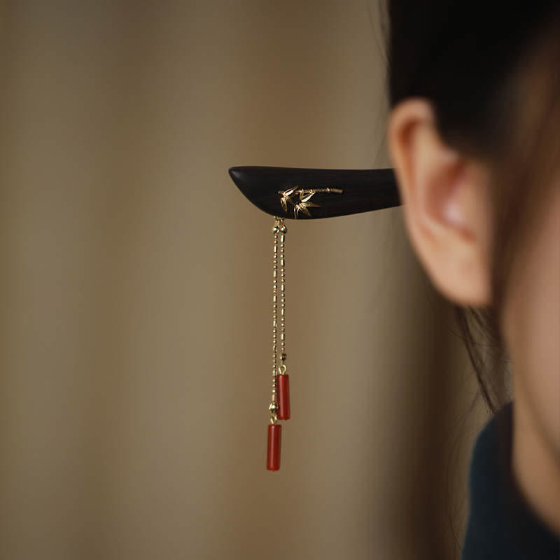 Side view of Red Agate & Ebony Wood Tassel Hairpin worn in hair, featuring gold bamboo leaf inlay and red agate cylinder tassels