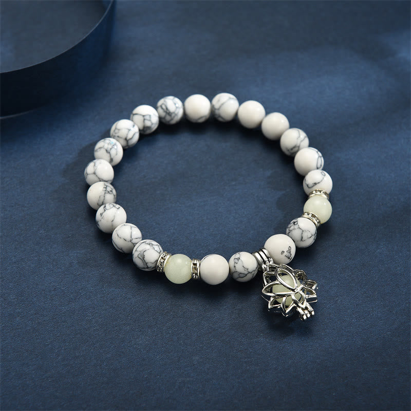 Tibetan Turquoise Glowstone Lotus Bracelet – white howlite beads with greenish-yellow glow on dark blue surface, glow bracelet