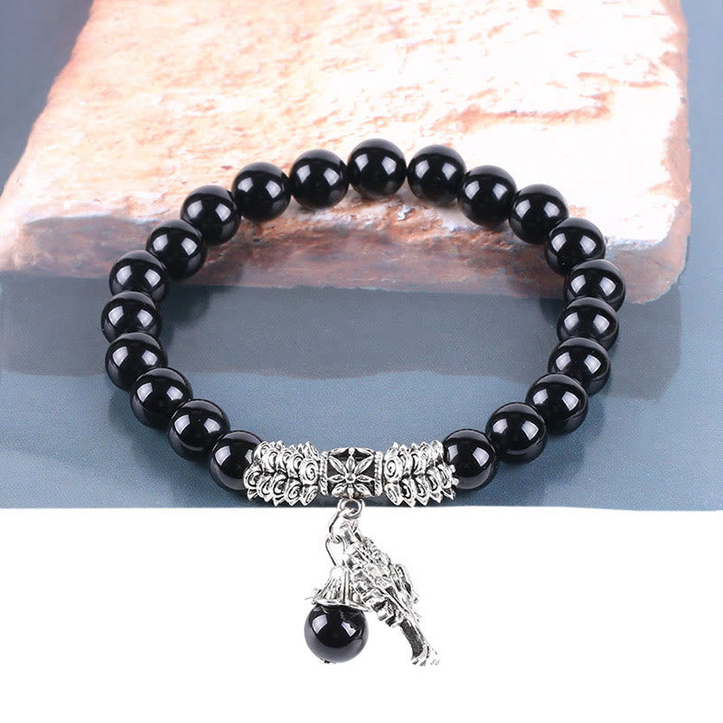 Tree of Life black onyx bracelet with polished black beads, silver-toned tree of life pendant, silver decorative metal accents.