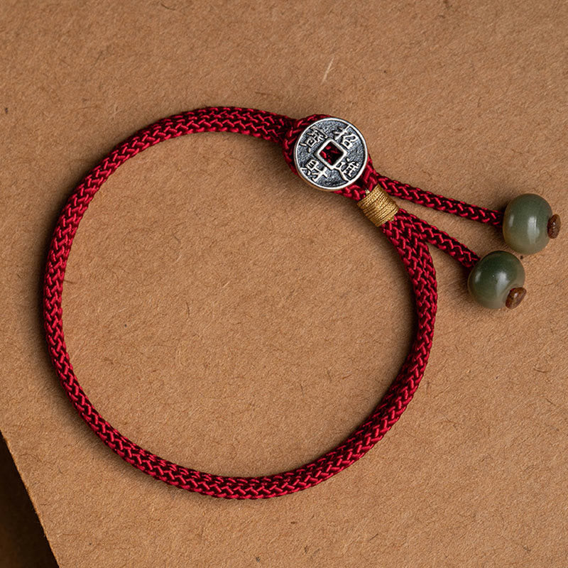 925 Silver Zodiac Natal Buddha Red String Bracelet on kraft paper, Fortune Copper Coin variant with Chinese prosperity characters, antique silver coin charm, sage green jade beads, gold wire wrap detail, adjustable cord