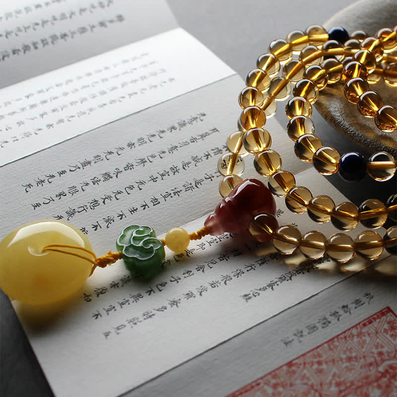 Citrine Mala Bracelet – Citrine mala on calligraphy book showing Buddhist scripture text