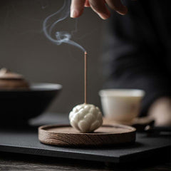 Ceramic Lotus Incense Burner on wooden base with lit incense, zen tea ceremony