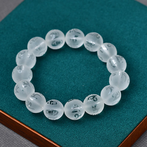 White Crystal Mantra Bracelet – Etched mantra beads on teal velvet jewelry display pad