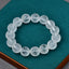 White Crystal Mantra Bracelet – Etched mantra beads on teal velvet jewelry display pad