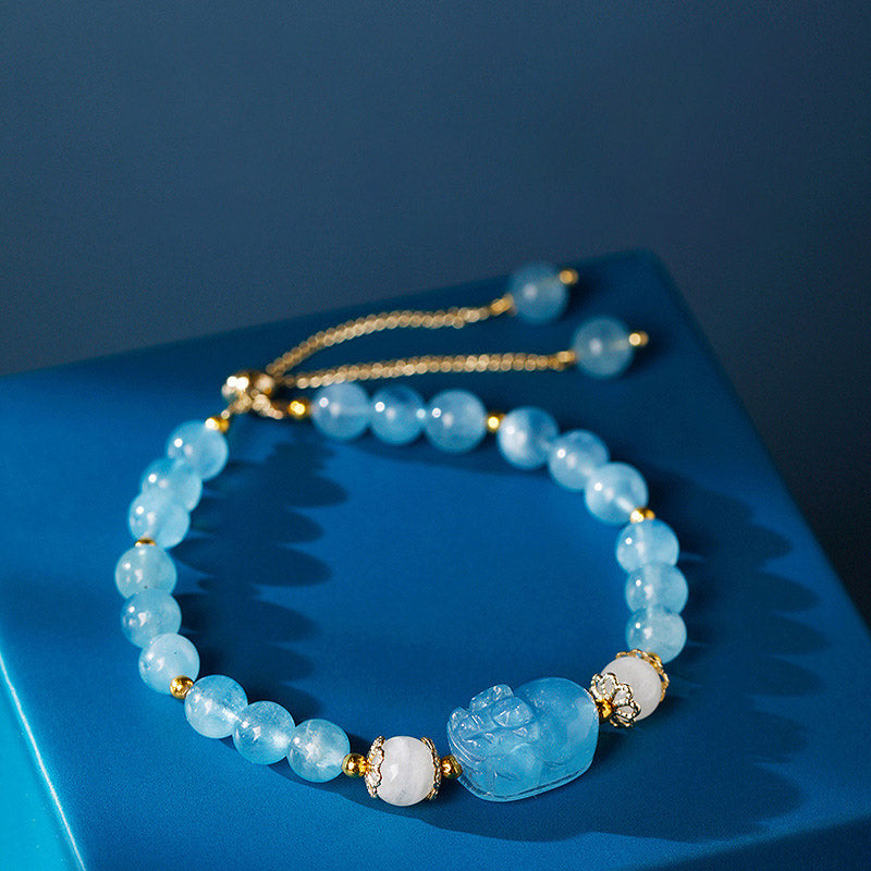 Aquamarine PiXiu Bracelet – aquamarine beads moonstone accents blue backdrop, healing crystal jewelry