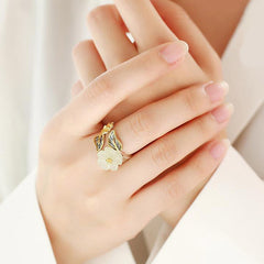 White Jade Plum Blossom Silver Ring - Ring on hand with cream-colored jade flower bloom, detailed leaf veining, and small bee or bud accent detail