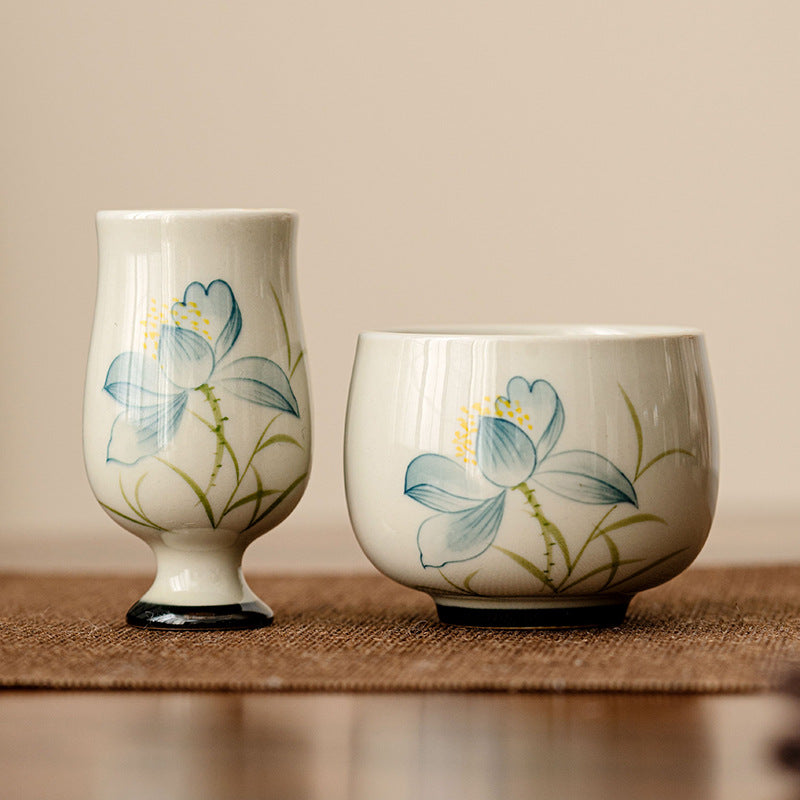 Hand Painted Lotus Tea Cup – tall stemmed and round bowl pair with blue lotus on cream glaze, matching set