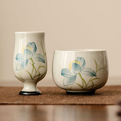 Hand Painted Lotus Tea Cup – tall stemmed and round bowl pair with blue lotus on cream glaze, matching set