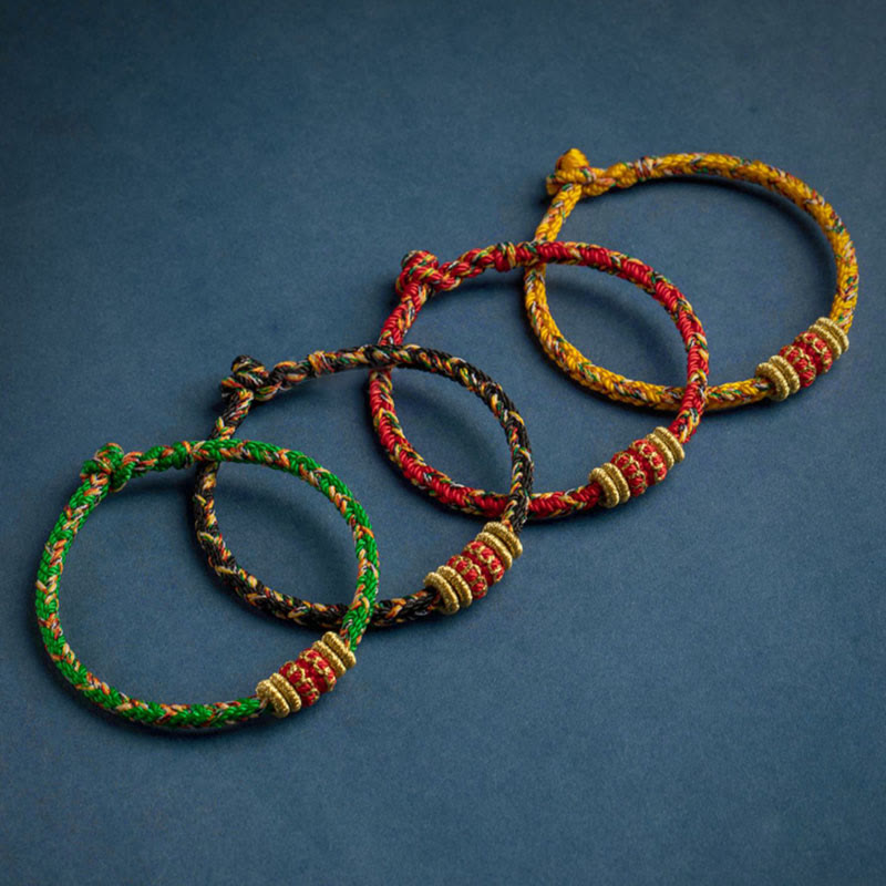 Set of four handmade braided cord bracelets in green black red and yellow with gold beads and red decorative bands, adjustable traditional Tibetan lucky rope jewelry