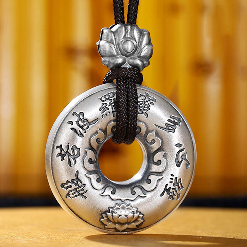 Silver Heart Sutra Pendant – brushed silver disc with sutra characters and lotus motifs on wood, zen jewelry