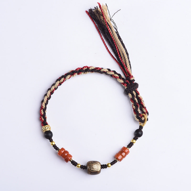 Cotton Cord Bracelet – flat lay white background with red beige black tassel ends, gold mantra bead, handmade style