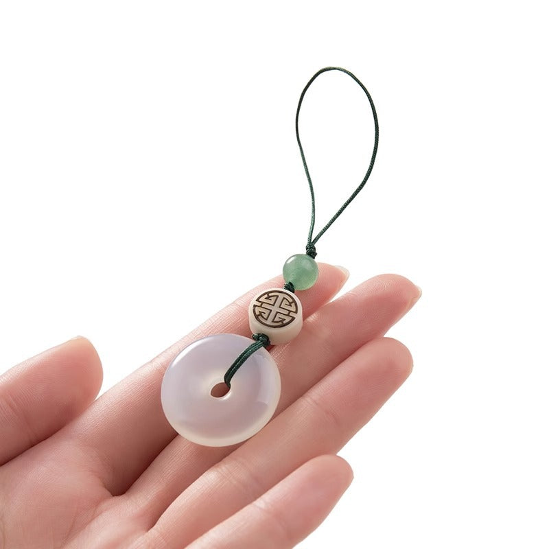 Chalcedony Peace Disc Keychain – jade bi disc held in palm showing translucent quality