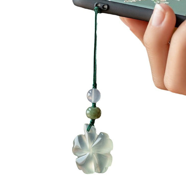 Jade Clover Keychain – clover pendant on phone strap, hand-held against clean white background