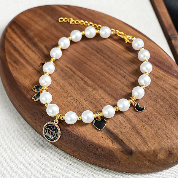 Luxury Crystal Pet Necklace – pearl collar with black crown medallion, star moon heart bow charms, wood tray
