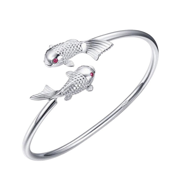 Double Fish Cuff – white background studio shot of silver koi open cuff with red eyes