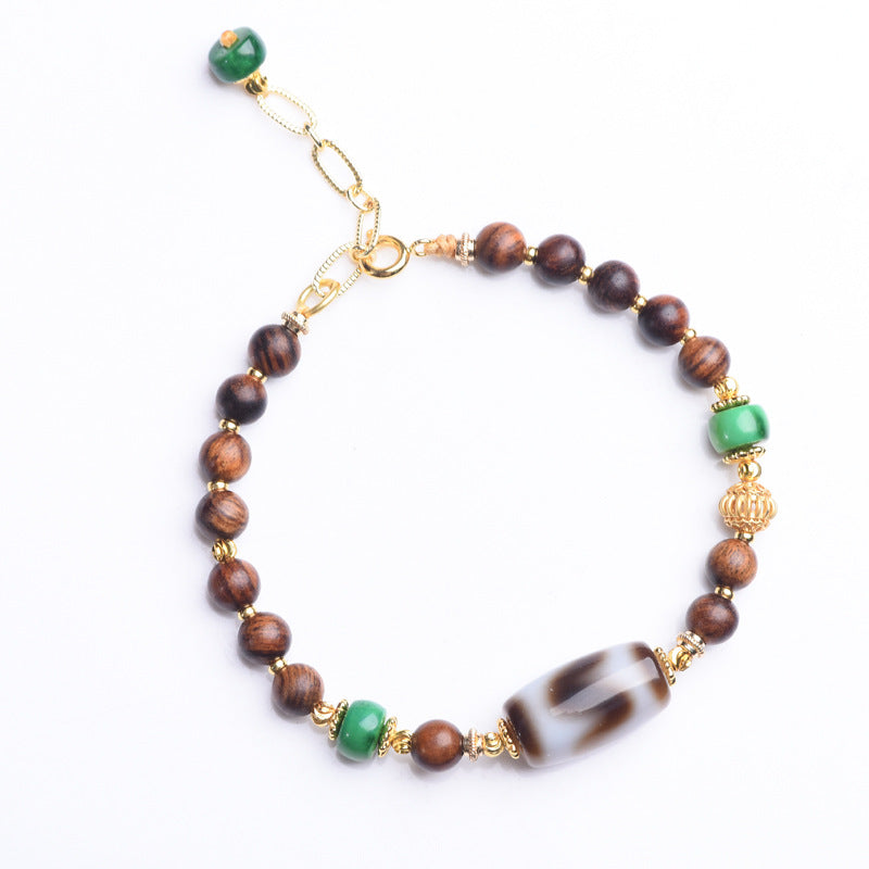 Dzi Rosewood Bracelet – Isolated rosewood bead bracelet with dzi centerpiece on white, Tibetan wellness gift