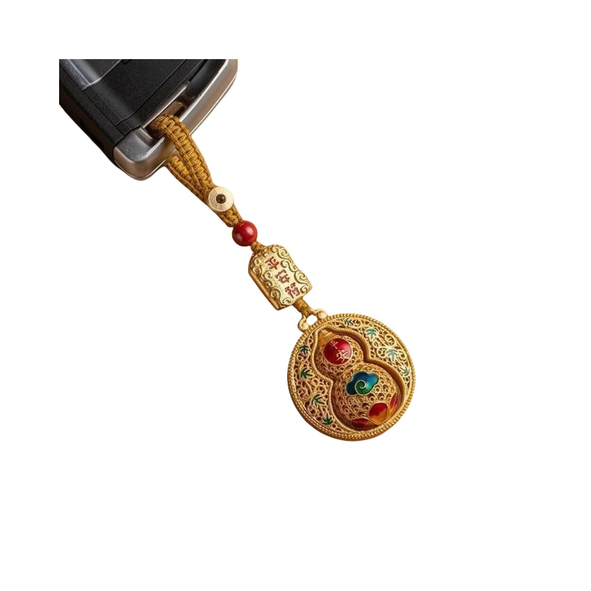 Hand holding gold rotating calabash disc keychain with longevity charm by car key, outdoor close-up