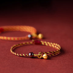 Red Gold Rope Lotus Braid Bracelet - paired bracelets with bokeh background, red string bracelet