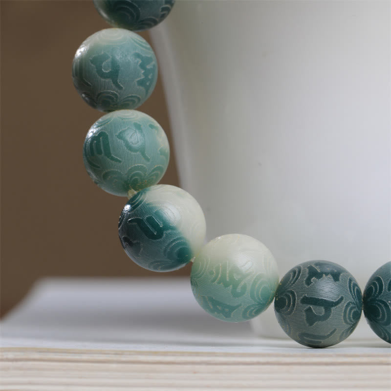 Bodhi Seed Om Mani Padme Hum Bracelet – Macro shot of mantra beads on cup rim with ombré teal gradient