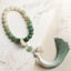 Bodhi Seed Lotus Wisdom Wrist Mala – Green ombre beaded bracelet with tassel on book, jade gradient prayer beads