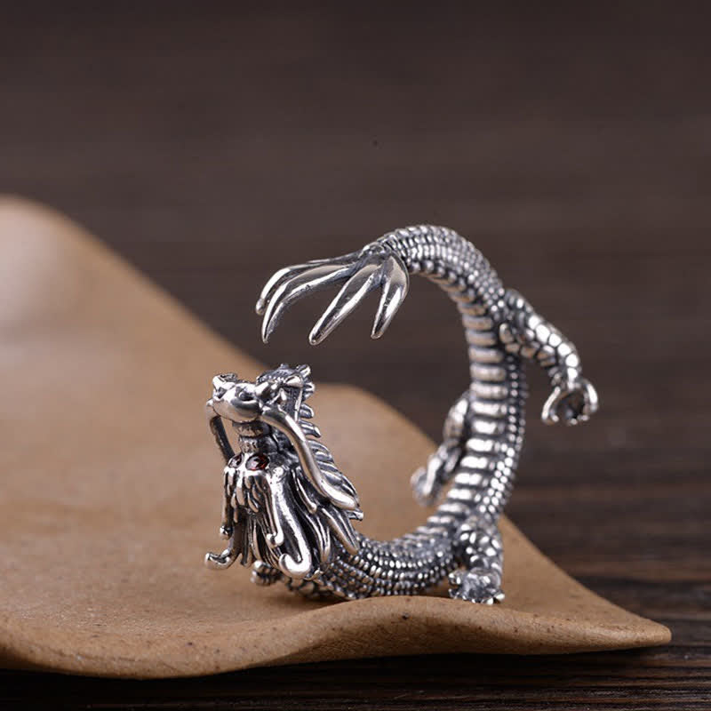 925 Sterling Silver Dragon Ring – Low angle view of dragon tail fin and coiled body on kraft paper, Sculptural