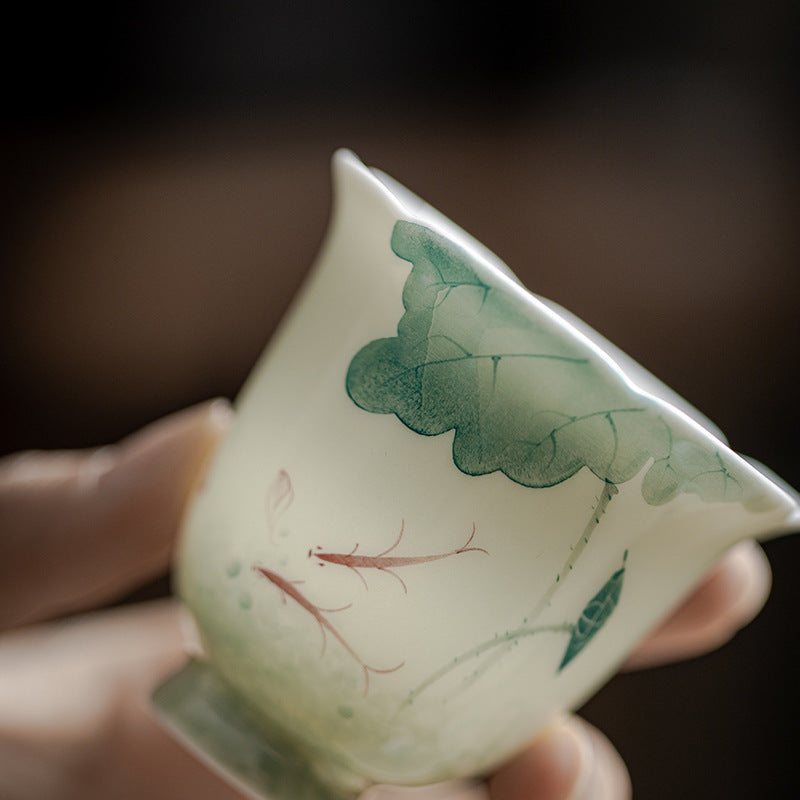 Koi Lotus Teacup – With green tea poured, koi pattern visible, ceramic cup