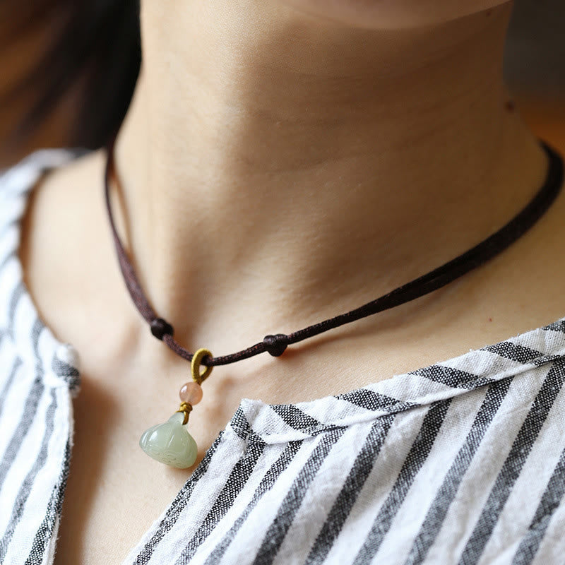 Jade Peace Buckle Lotus Necklace – Gourd-shaped jade pendant on cord worn as choker on striped shirt, jade pendant