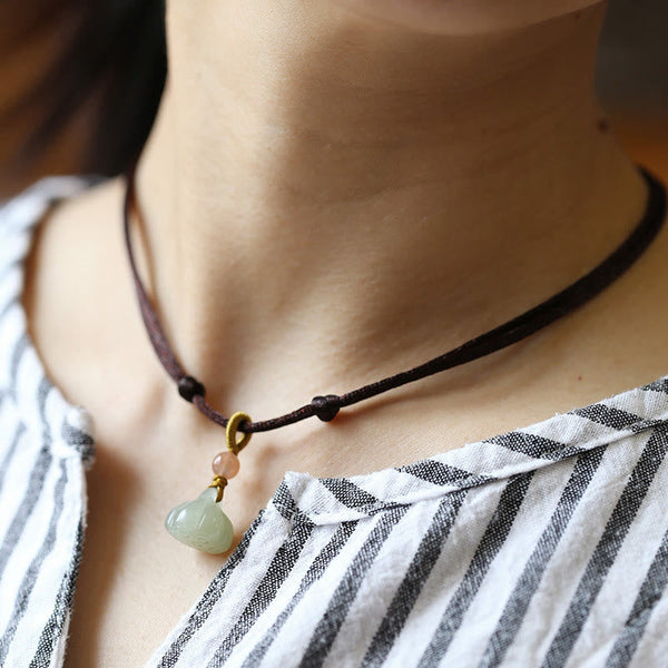 Jade Peace Buckle Lotus Necklace – Gourd-shaped jade pendant on cord worn as choker on striped shirt, jade pendant