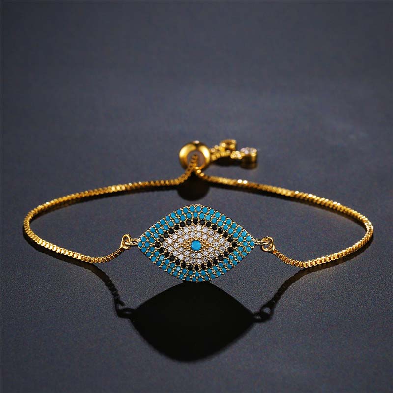Evil Eye Healing Bracelet – Gold adjustable nazar bracelet with pave blue evil eye on dark surface