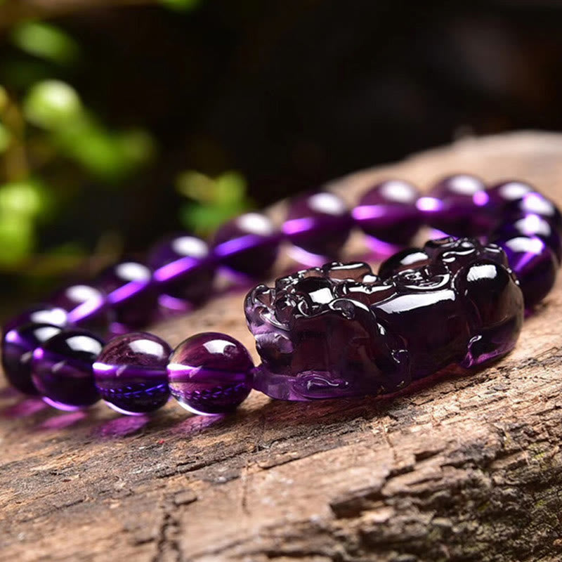 Amethyst PiXiu Fortune Bracelet – Low angle PiXiu on tree bark with green bokeh, wealth bracelet