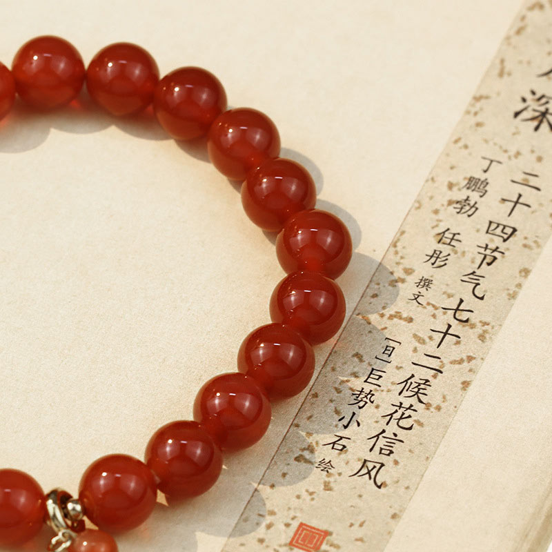 Red Agate Buddha Bracelet - Beads detail beside Chinese calligraphy paper scroll