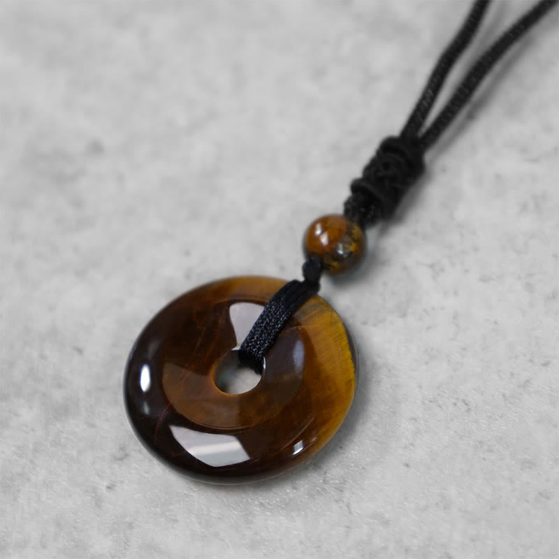 Lucky Coin Pendant Healing Crystal Gemstone Necklace – Tiger's eye peace buckle necklace worn casually over white shirt and gray jacket