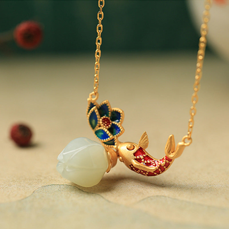 White Jade Koi Fish Necklace – dual lotus design with enameled flower and jade bud on beige, green red bokeh background