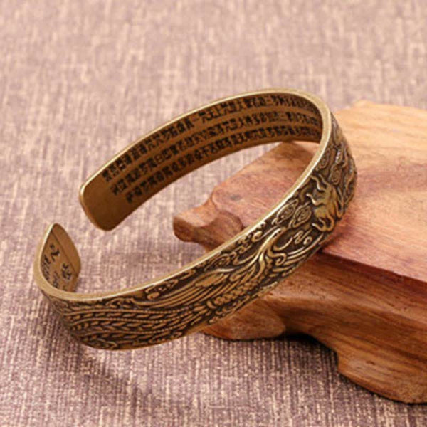 Om Mani Padme Hum Dragon Phoenix Bracelet - Brass cuff with phoenix engraving and sutra text on wood stand, Heritage
