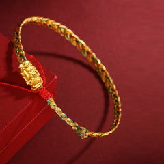 Colorful Dragon Carved Braided Bracelet – Gold charm on colorful cord over red gift box, angled display, Prosperous