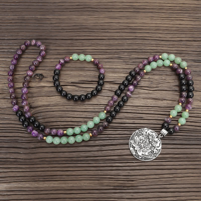 Amethyst Aventurine Lotus Mala - Mala necklace with lotus pendant in three loops on dark wood, prayer beads