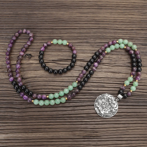 Amethyst Aventurine Lotus Mala - Mala necklace with lotus pendant in three loops on dark wood, prayer beads