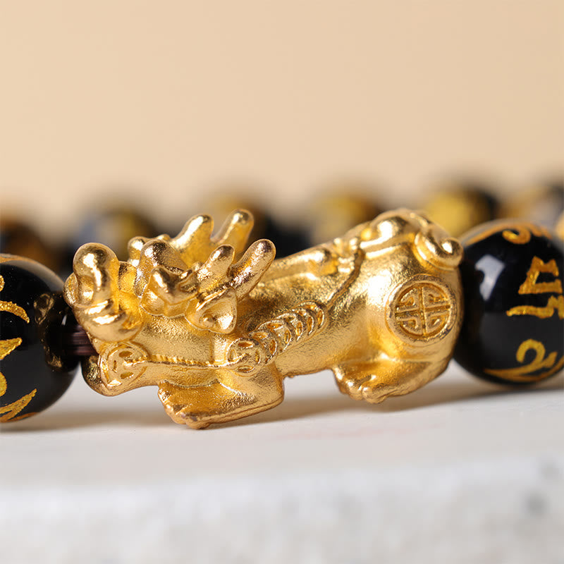 Obsidian Six-Word Mantra PiXiu Bracelet – macro side view of golden PiXiu with engraved details between black beads, prosperity