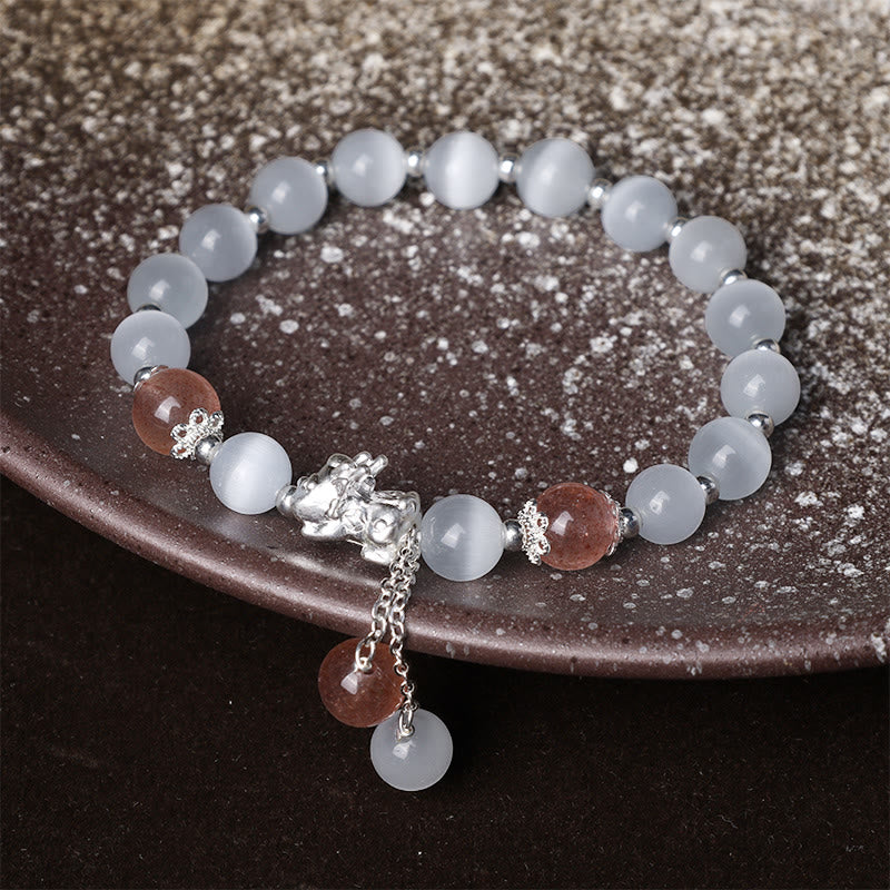 Cat's Eye PiXiu Bracelet – Dark ceramic plate display with strawberry quartz and white cat's eye