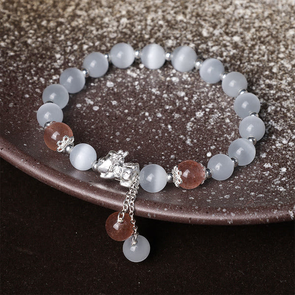 Cat's Eye PiXiu Bracelet – Dark ceramic plate display with strawberry quartz and white cat's eye