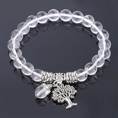 Tree of Life clear quartz bracelet with transparent crystal beads, silver-toned spacers, tree of life pendant and clear bead dangle charm.