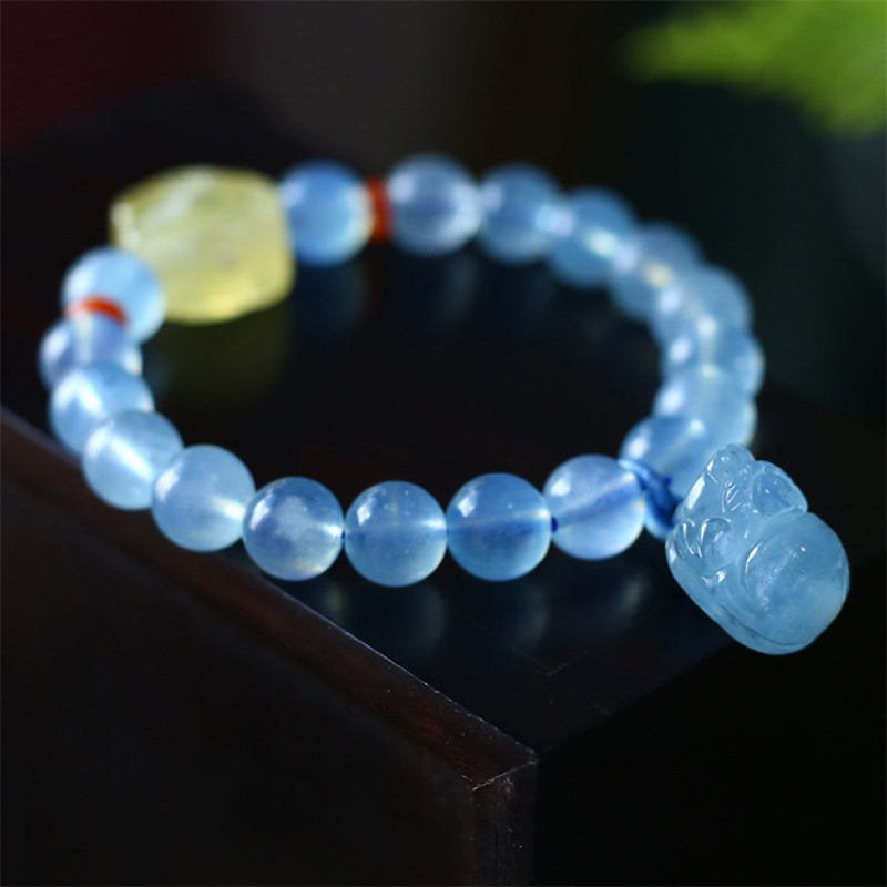 Aquamarine PiXiu Bracelet – Side view on black edge showing blue PiXiu charm and beads, serenity jewelry