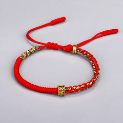 Om Mani Padme Hum Red String Bracelet – Red braided rope with five-color woven section and gold Om Mani Padme Hum mantra bead on light background