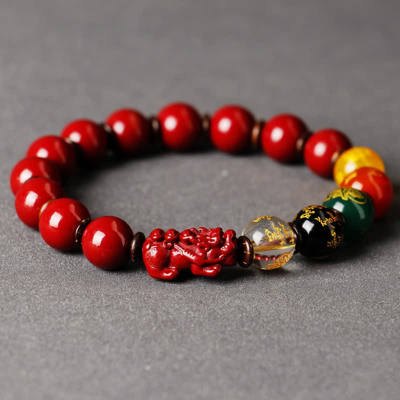 Cinnabar PiXiu Blessing Bracelet – Close-up of red cinnabar PiXiu with crystal and black gold beads on gray