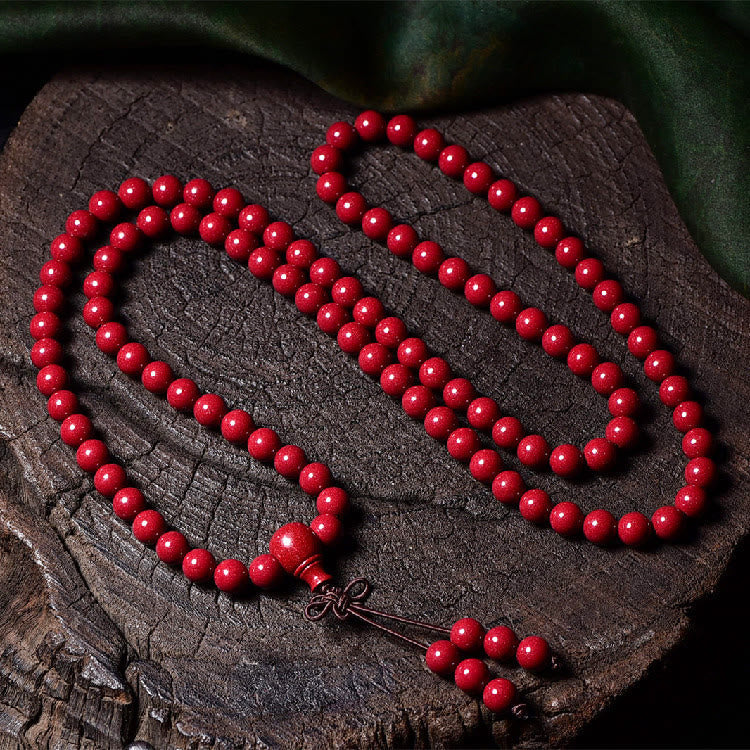 108 Mala Beads Cinnabar Bracelet – Top-down on wood cross-section, guru bead detail