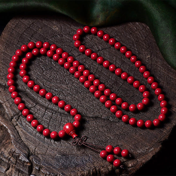 108 Mala Beads Cinnabar Bracelet – Top-down on wood cross-section, guru bead detail