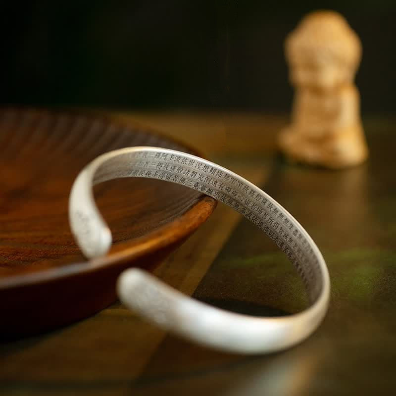 Lotus Cuff Bracelet – Silver open bangle with engraved lotus terminals on wrist, lotus bracelet