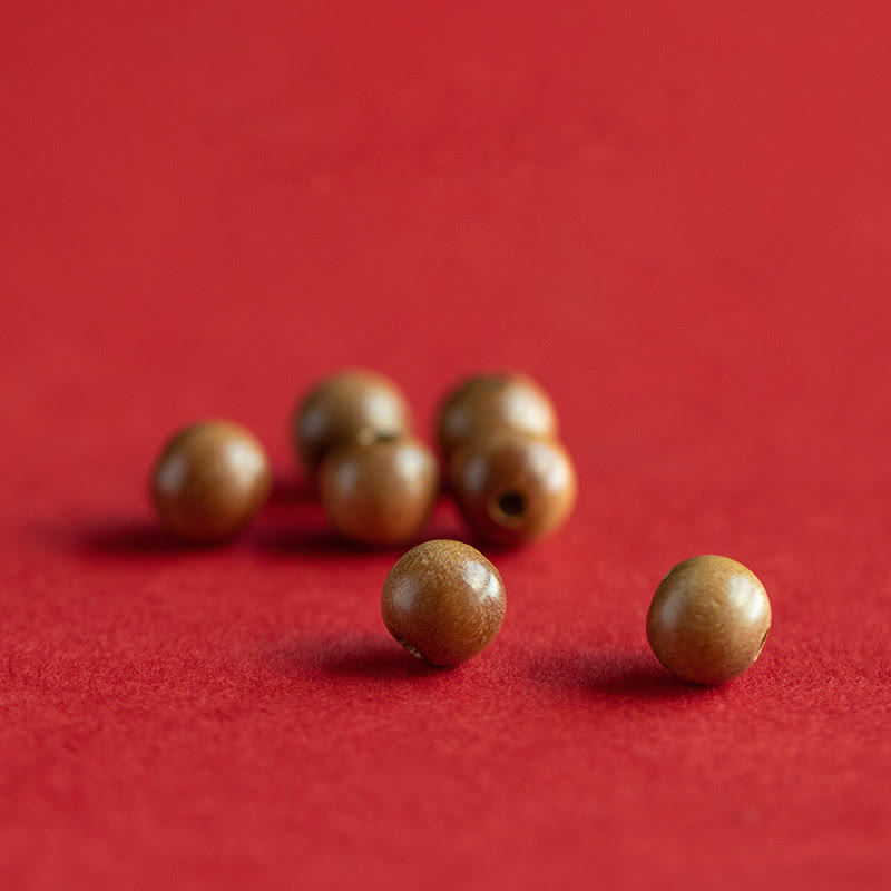 Peach Wood & Cinnabar Lotus Bracelet loose wooden beads on red fabric, natural wood grain craft material, artisan