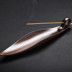 Ceramic Incense Burner – Glazed brown boat holder with lit incense wisp on dark backdrop, Calm